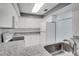 Well-lit kitchen with white appliances, cabinets, and granite countertops at 1933 Whitney Way, Clearwater, FL 33760