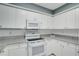 Bright kitchen with white cabinets, appliances, and granite countertops at 1933 Whitney Way, Clearwater, FL 33760