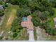 Aerial view of home with screened in pool in a lush, wooded area at 204 Oak Lake Dr, Spring Hill, FL 34608