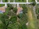Aerial view of the property featuring a pool, lush trees, and a well-maintained lawn at 204 Oak Lake Dr, Spring Hill, FL 34608