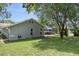 Exterior view of the home highlighting the spacious backyard and lush landscaping at 204 Oak Lake Dr, Spring Hill, FL 34608