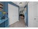 Hallway with white bi-fold doors, light tile flooring, and blue walls leading to a cozy living space at 204 Oak Lake Dr, Spring Hill, FL 34608
