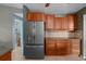 Bright kitchen featuring stainless steel refrigerator and warm wood cabinetry at 204 Oak Lake Dr, Spring Hill, FL 34608