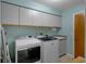 Bright laundry room featuring modern washer and dryer units, ample cabinet space, and an utility sink at 204 Oak Lake Dr, Spring Hill, FL 34608