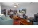 Cozy living room with dark wood floors, TV, desk and comfortable seating, perfect for relaxation and entertainment at 204 Oak Lake Dr, Spring Hill, FL 34608