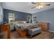A bright main bedroom featuring an attractive ceiling fan and large windows showing the backyard at 204 Oak Lake Dr, Spring Hill, FL 34608