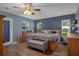 Spacious main bedroom featuring a ceiling fan, two windows, and a large wooden bed frame at 204 Oak Lake Dr, Spring Hill, FL 34608