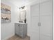 Stylish bathroom with gray vanity, decorative mirror, modern lighting, and storage cabinet at 2326 Auburn S St, St Petersburg, FL 33712