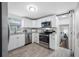 Modern kitchen with white cabinets, stainless steel appliances, granite counters, and a view into the bedroom at 2326 Auburn S St, St Petersburg, FL 33712