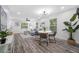 Open-concept living space featuring dining area and living room with wood-look floors and ample natural light at 2326 Auburn S St, St Petersburg, FL 33712