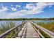 Picturesque view of a wooden dock extending into a serene lake, surrounded by lush vegetation at 2330 Ecuadorian Way # 30, Clearwater, FL 33763