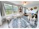 Bright living room featuring large windows, a comfortable seating area, and a stylish palm-leaf patterned rug at 2330 Ecuadorian Way # 30, Clearwater, FL 33763