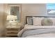 Bedroom showcasing a comfy bed, side table with lamp, mirror, and a bright window view at 243 45Th Ne Ave, St Petersburg, FL 33703