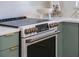 Close up of the stainless range and modern green cabinetry in this updated kitchen at 243 45Th Ne Ave, St Petersburg, FL 33703