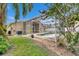 Backyard with an enclosed pool, garden with decorative stones and palm trees at 25327 Seven Rivers Cir, Land O Lakes, FL 34639