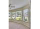 Sunlit bedroom with large windows, plush carpet, and ceiling fan at 25327 Seven Rivers Cir, Land O Lakes, FL 34639