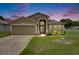 Charming single-story home with a well-manicured lawn and inviting curb appeal at dusk at 25327 Seven Rivers Cir, Land O Lakes, FL 34639