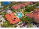 Aerial view of a community with a luxurious pool area, ample parking, and beautiful landscaping at 2724 Via Murano # 639, Clearwater, FL 33764