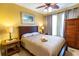 Bedroom featuring wooden furniture, bedside lamps, a ceiling fan, and neutral colors at 2724 Via Murano # 639, Clearwater, FL 33764