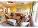 Comfortable living room featuring a leather sofa, decorative lamps, and a ceiling fan at 2724 Via Murano # 639, Clearwater, FL 33764