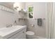 Bathroom featuring white vanity, toilet, marble shelving, modern fixtures, and window at 2834 10Th N Ave, St Petersburg, FL 33713