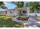 Single-story home featuring a cozy front porch, fresh landscaping, and a well-maintained lawn at 2834 10Th N Ave, St Petersburg, FL 33713