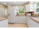 Bright kitchen with white cabinets, stainless steel sink, and a window overlooking greenery at 2834 10Th N Ave, St Petersburg, FL 33713