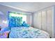 Bedroom featuring a bed with a blue floral comforter, plush toy, and bright window at 3119 Roberta St, Largo, FL 33771