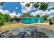 Backyard exterior view of the home showing the screened porch and turquoise exterior at 3119 Roberta St, Largo, FL 33771