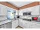 Bright kitchen with white cabinetry, stainless steel appliances, and tile backsplash at 3119 Roberta St, Largo, FL 33771
