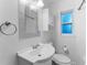 Bright bathroom with a single sink, decorative mirror, window and white toilet at 3215 W Villa Rosa St, Tampa, FL 33611