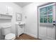 This bathroom has a wooden-look floor, toilet, sink, storage cabinet, and a door to the outside at 3215 W Villa Rosa St, Tampa, FL 33611