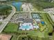 Aerial view showcasing the community amenities, pool, tennis courts, and surrounding landscape at 3326 Acacia Bay Ave, Wesley Chapel, FL 33543