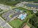 Aerial view of a community with a large pool, clubhouse, and surrounding homes at 3326 Acacia Bay Ave, Wesley Chapel, FL 33543