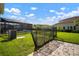 Well-maintained backyard showcases lush greenery, a secure fence, pool cage, and adds privacy to the outdoor living at 3326 Acacia Bay Ave, Wesley Chapel, FL 33543