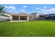 Spacious backyard with lush green lawn, covered patio, and black metal fencing at 3326 Acacia Bay Ave, Wesley Chapel, FL 33543