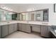 Bright bathroom featuring a double sink vanity with gray cabinets and large mirrors, offering ample counter space at 3326 Acacia Bay Ave, Wesley Chapel, FL 33543