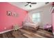 Charming bedroom showcasing a pink accent wall, wood floors, and a playful canopy bed with cute decorations at 3326 Acacia Bay Ave, Wesley Chapel, FL 33543