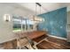 Bright dining room with stylish light fixture and decorative blue accent wall paneling at 3326 Acacia Bay Ave, Wesley Chapel, FL 33543