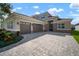Stunning home with a three-car garage, well-manicured lawn, and a paver driveway, exhibiting great curb appeal at 3326 Acacia Bay Ave, Wesley Chapel, FL 33543