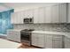 Well-equipped kitchen with gray cabinets, stainless steel appliances, and mosaic backsplash at 3326 Acacia Bay Ave, Wesley Chapel, FL 33543