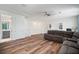 Spacious living area featuring hard floors, a large couch, built-in shelving, and access to a modern bathroom at 3326 Acacia Bay Ave, Wesley Chapel, FL 33543