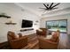 A living room features wood floors, a black ceiling fan, and an entertainment center at 3326 Acacia Bay Ave, Wesley Chapel, FL 33543