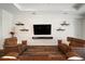Comfortable living room with floating shelves, television, and hardwood floors at 3326 Acacia Bay Ave, Wesley Chapel, FL 33543