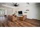A bright living room features wood floors, modern ceiling fan, and entertainment center at 3326 Acacia Bay Ave, Wesley Chapel, FL 33543
