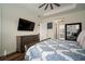Spacious main bedroom with ceiling fan and a beautiful patterned bedspread and mounted TV at 3326 Acacia Bay Ave, Wesley Chapel, FL 33543