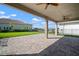 Spacious covered patio with ceiling fans offering picturesque view of the well-maintained lawn and serene landscape at 3326 Acacia Bay Ave, Wesley Chapel, FL 33543