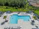 Overhead aerial view of a sparkling pool area with lounge chairs and shaded seating for relaxing at 3326 Acacia Bay Ave, Wesley Chapel, FL 33543
