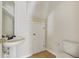 Well-lit half bathroom features a tiled floor, pedestal sink, and convenient toilet at 3406 Dragon View Ct, Valrico, FL 33594