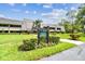 Well-maintained condo complex with lush landscaping and clear signage under a bright blue sky at 36750 Us 19 N # 20311, Palm Harbor, FL 34684